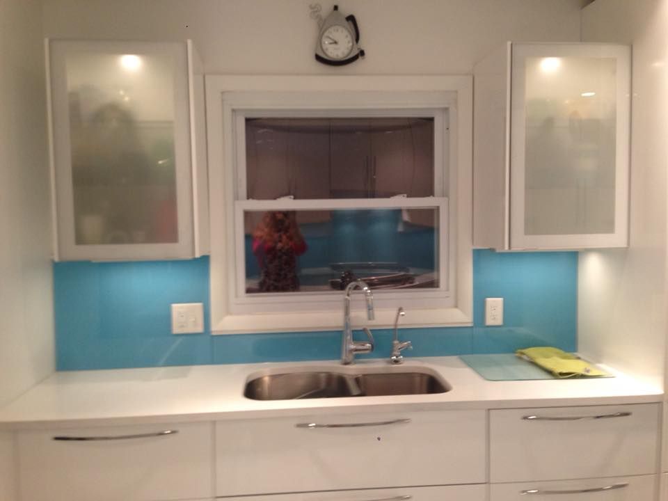 A kitchen with white cabinets a sink and a window