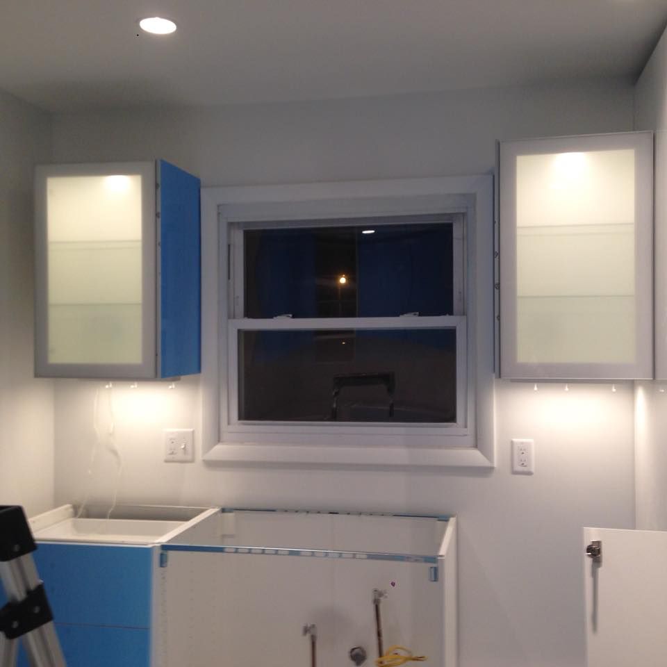 A kitchen with blue cabinets and a window
