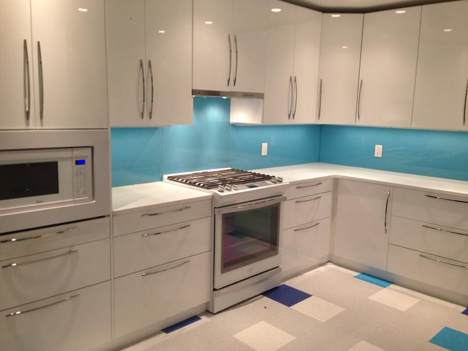 A kitchen with white cabinets and blue walls