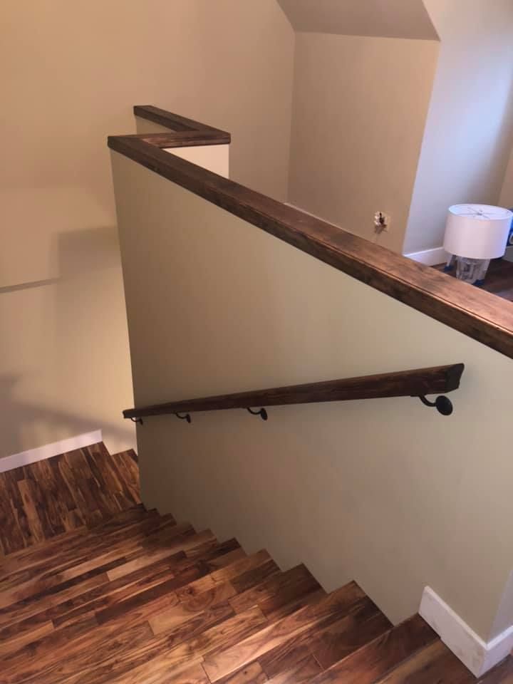 A wooden staircase with a wooden hand railing