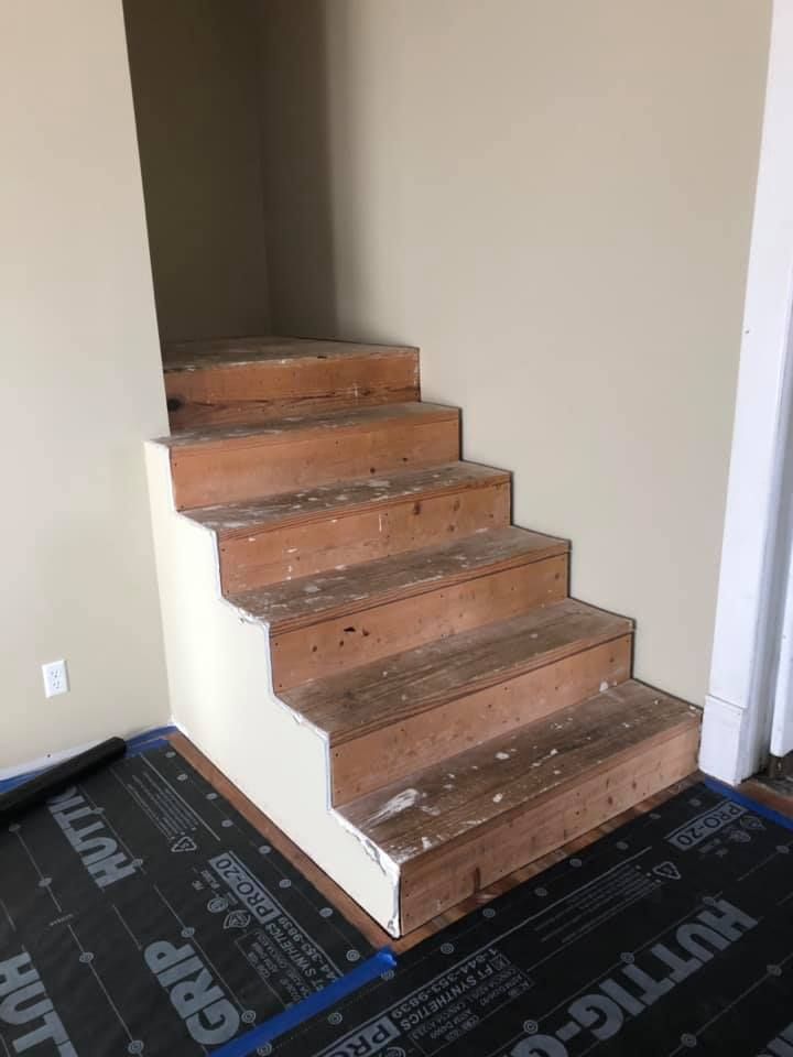 A wooden staircase is being built in a room.