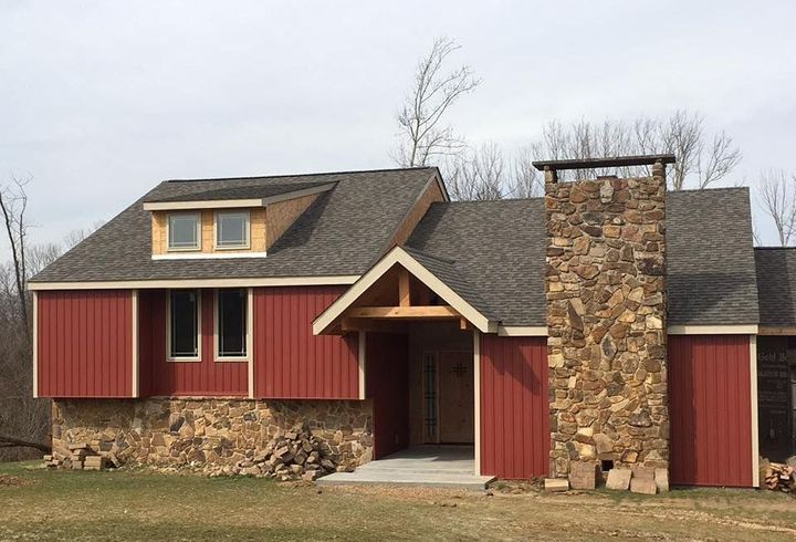 A house with red siding and a stone chimney