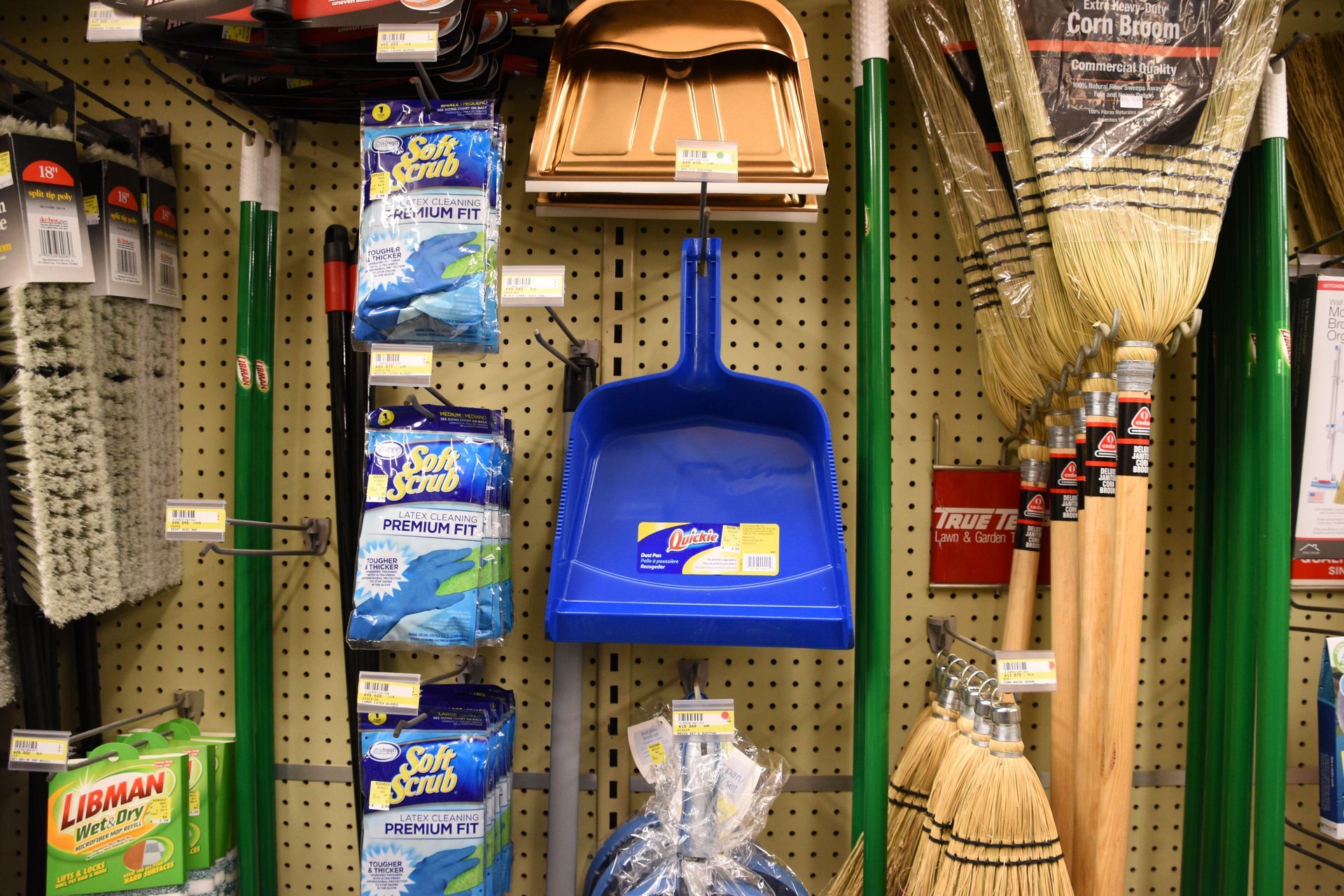 A variety of cleaning supplies are displayed on a wall in a store.