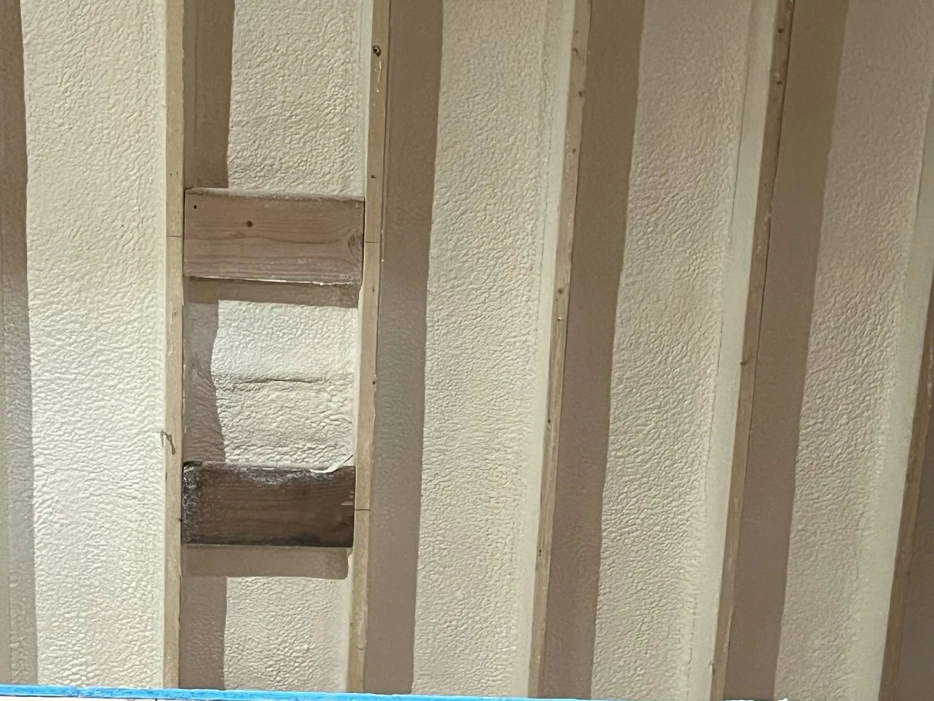 Close-up of beige metal railing bars with a small wooden spacer between them