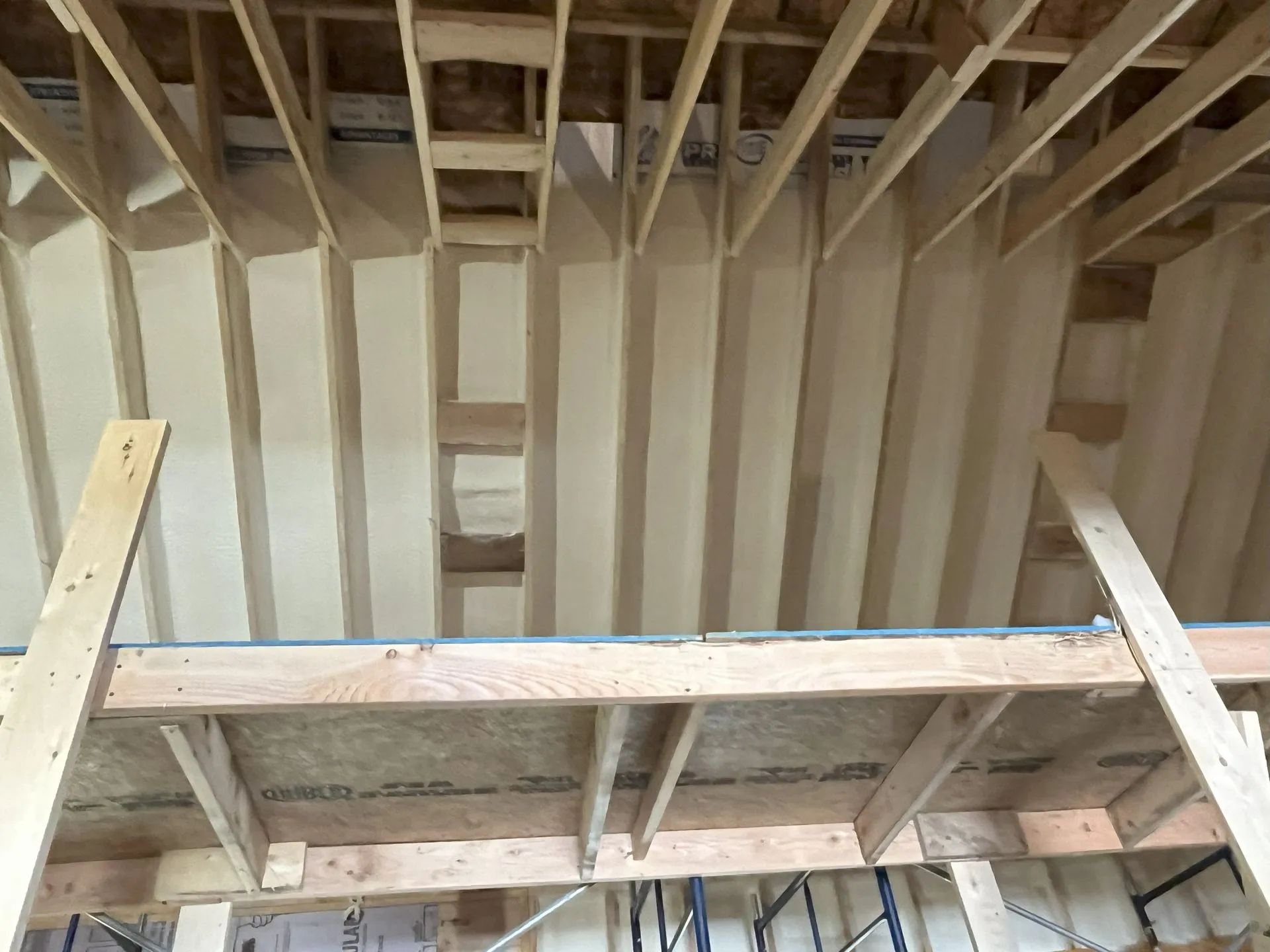 Unfinished room framing with exposed wooden studs, joists, and a rough ceiling opening.