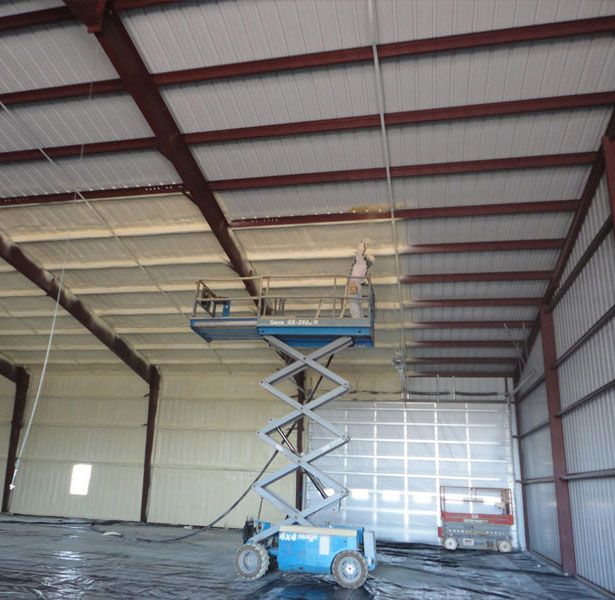 A man on a scissor lift in a large building