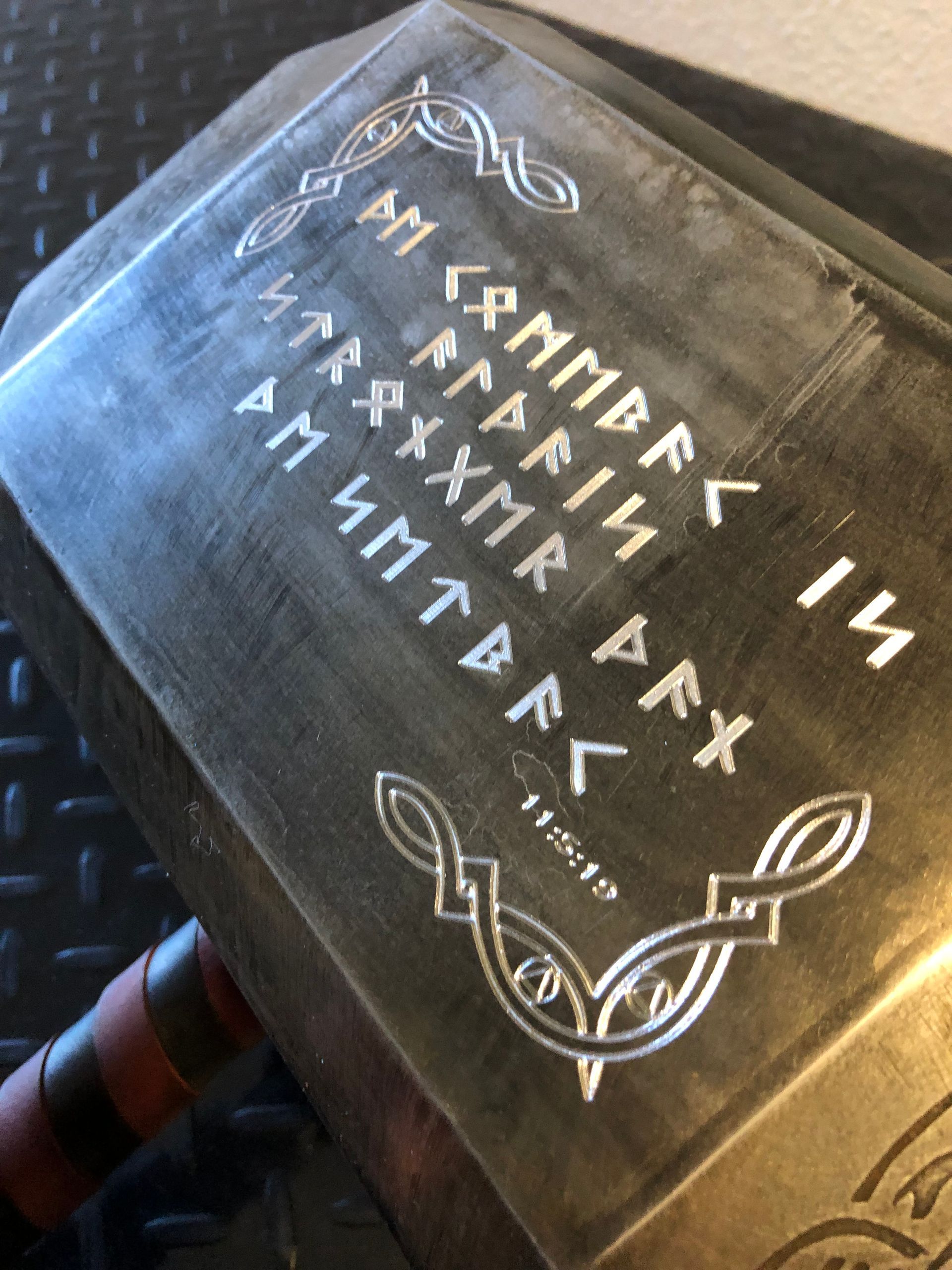 A close up of a hammer with runes on it