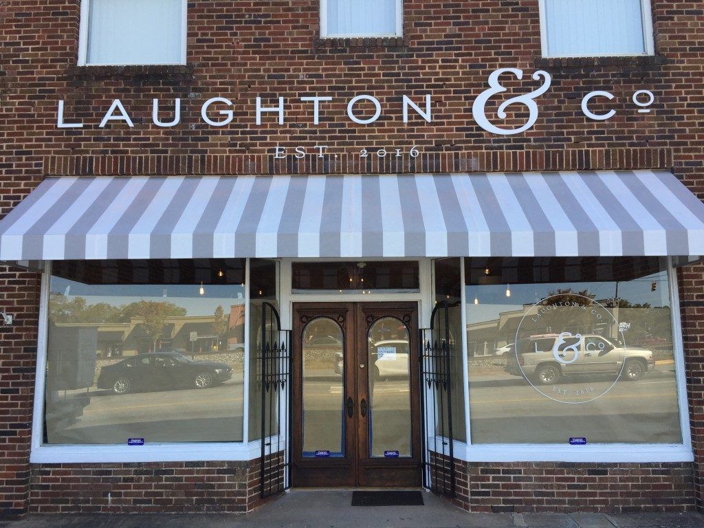 A store front with a striped awning that says laughton & co.