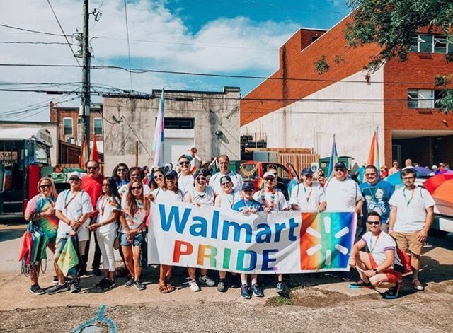 A group of people holding a walmart pride banner
