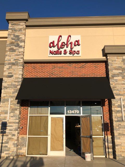 A building with a sign that says aloha nails & spa