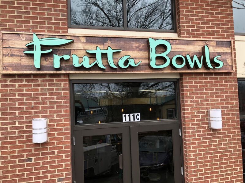 A brick building with a sign that says frutta bowls on it