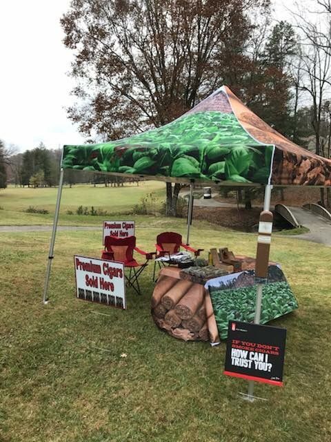A tent is sitting in the middle of a grassy field.