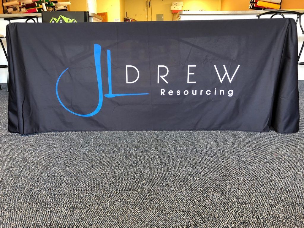 A black table cloth with the word drew on it