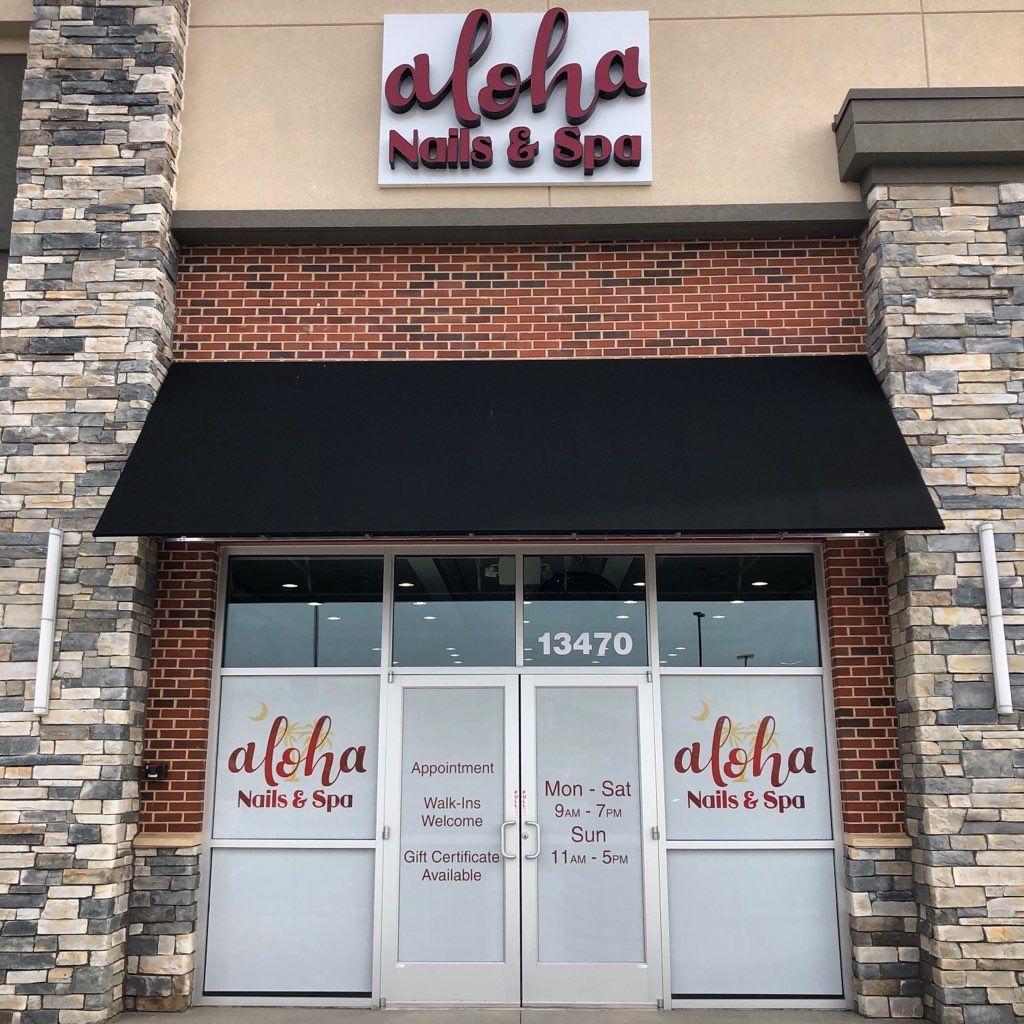 A brick building with a sign that says aloha nails & spa