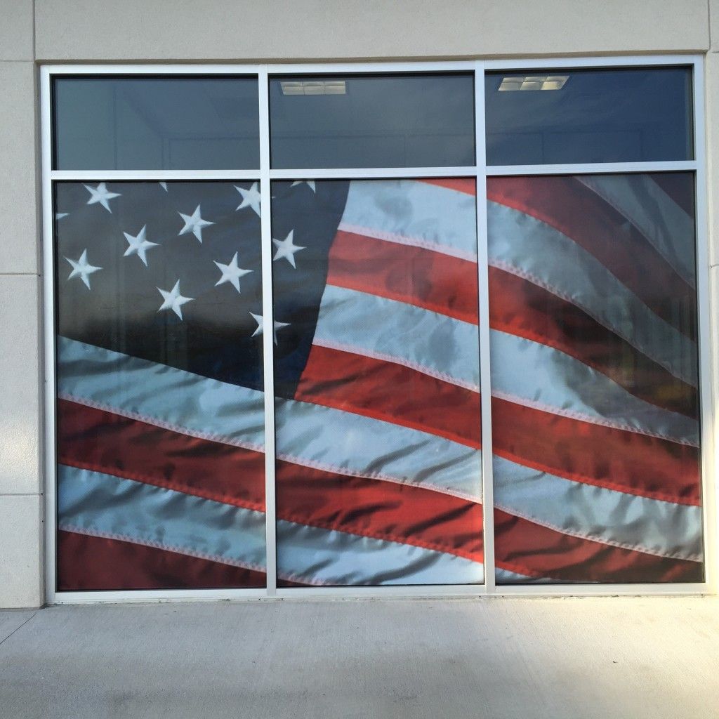 A large american flag is displayed in a window