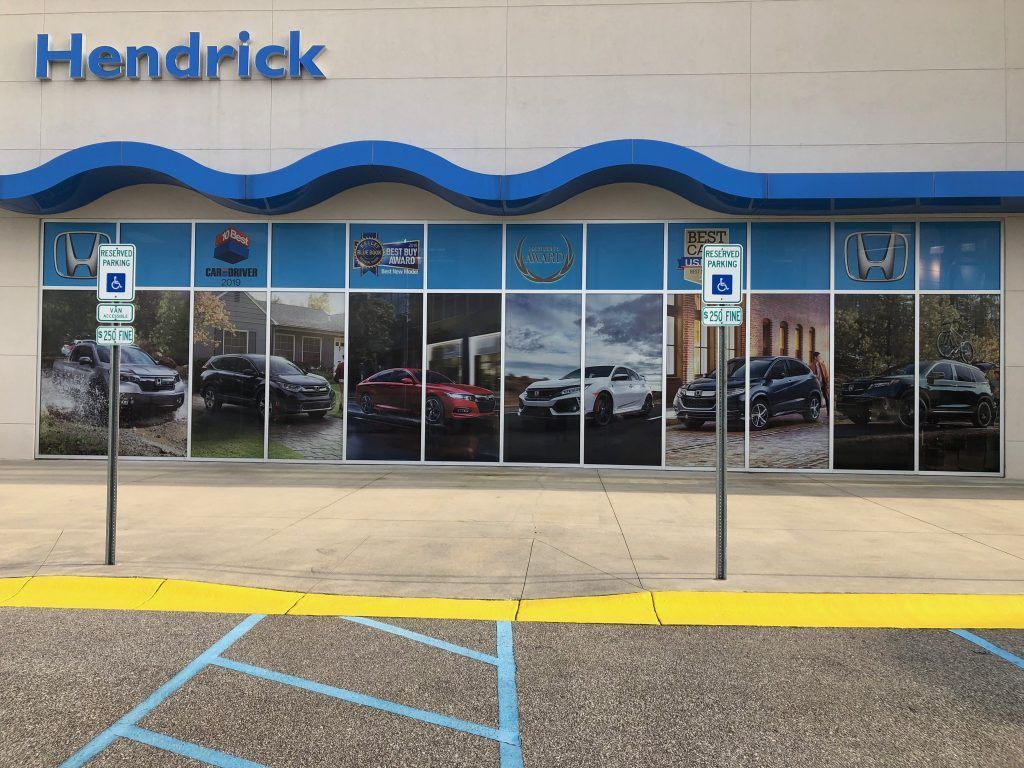 A car dealership with a lot of cars on the windows.