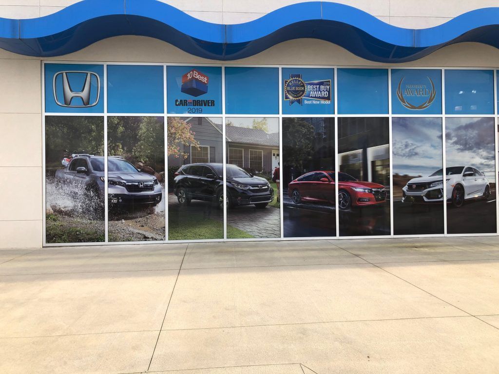 A car dealership with a lot of cars on the windows.
