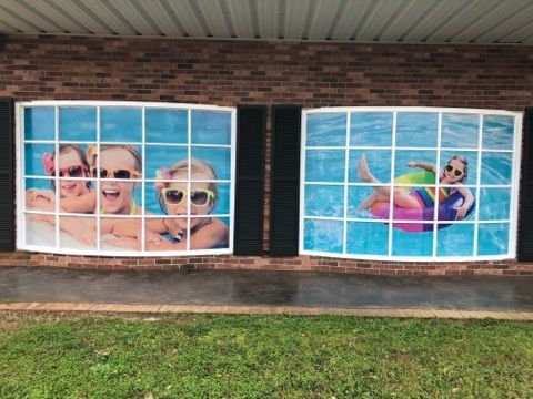 Two windows with pictures of people in a pool on them