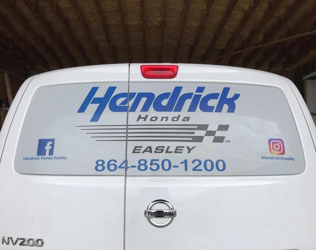A hendrick honda van is parked in a garage