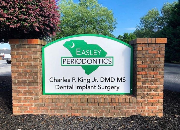 A sign for easley periodontics says charles p. king jr. dmd ms dental implant surgery