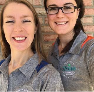 Two women wearing glasses and polo shirts are smiling for a picture.