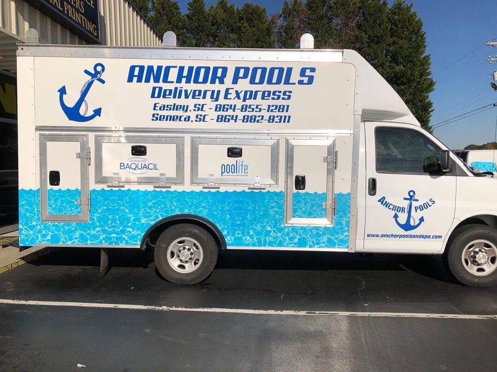 An anchor pools delivery truck is parked in a parking lot