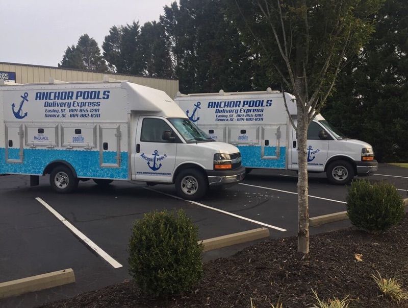 Two anchor pools vans are parked in a parking lot