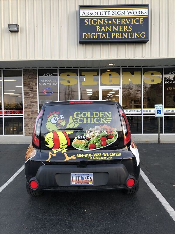 A car is parked in front of absolute sign works