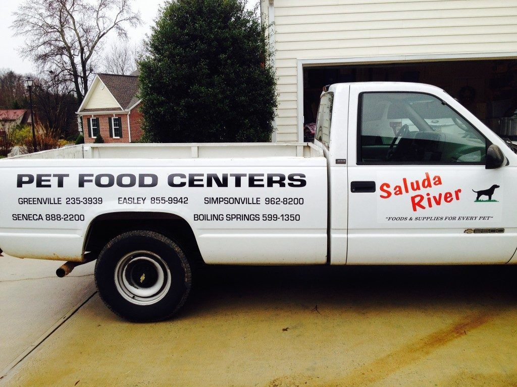 A white pet food centers truck is parked in a driveway