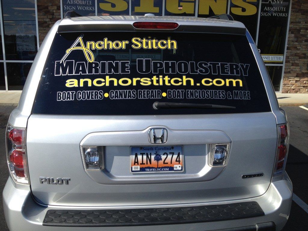 A silver honda with a sticker on the back window that says anchor stitch marine upholstery