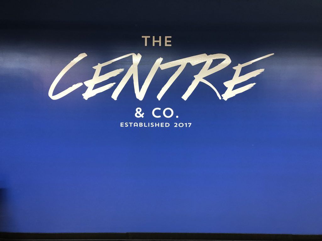 A blue sign that says the centre & co. on it