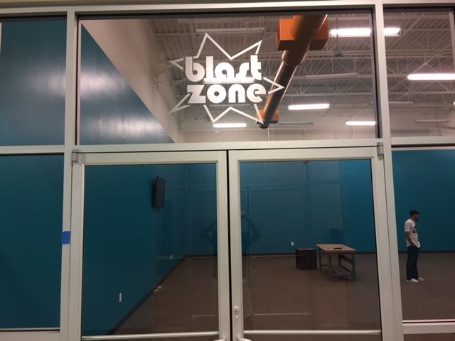 A man stands in front of a door that says black zone