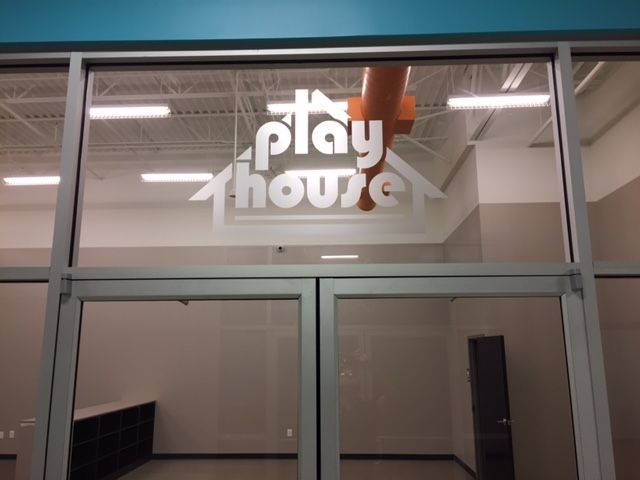 A glass door with the words play house on it