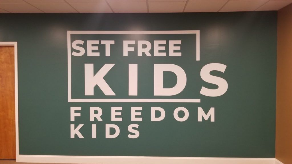 A sign on a wall that says set free kids freedom kids