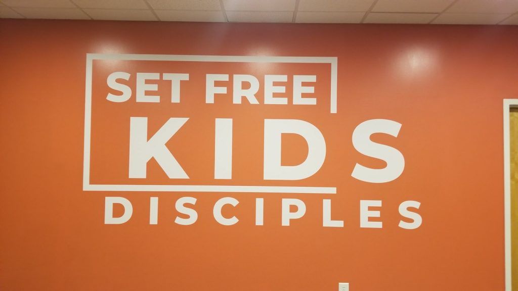 A sign on a wall that says set free kids disciples