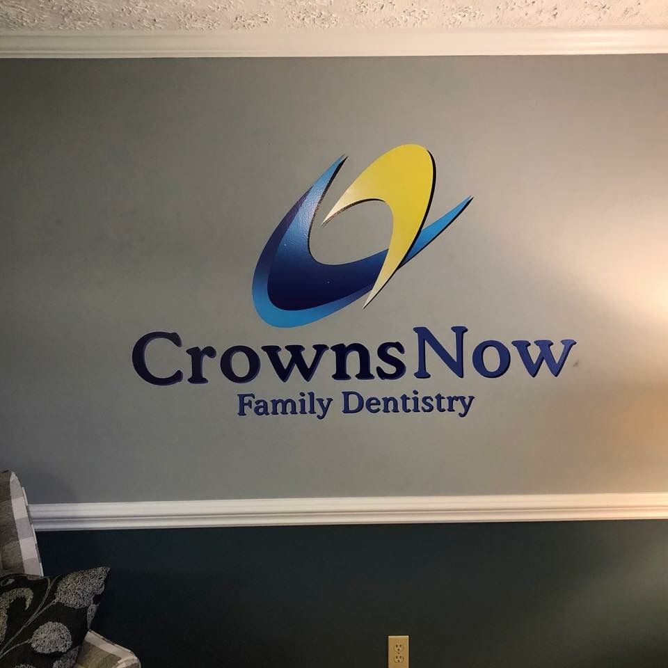 A sign for crowns now family dentistry hangs on a wall