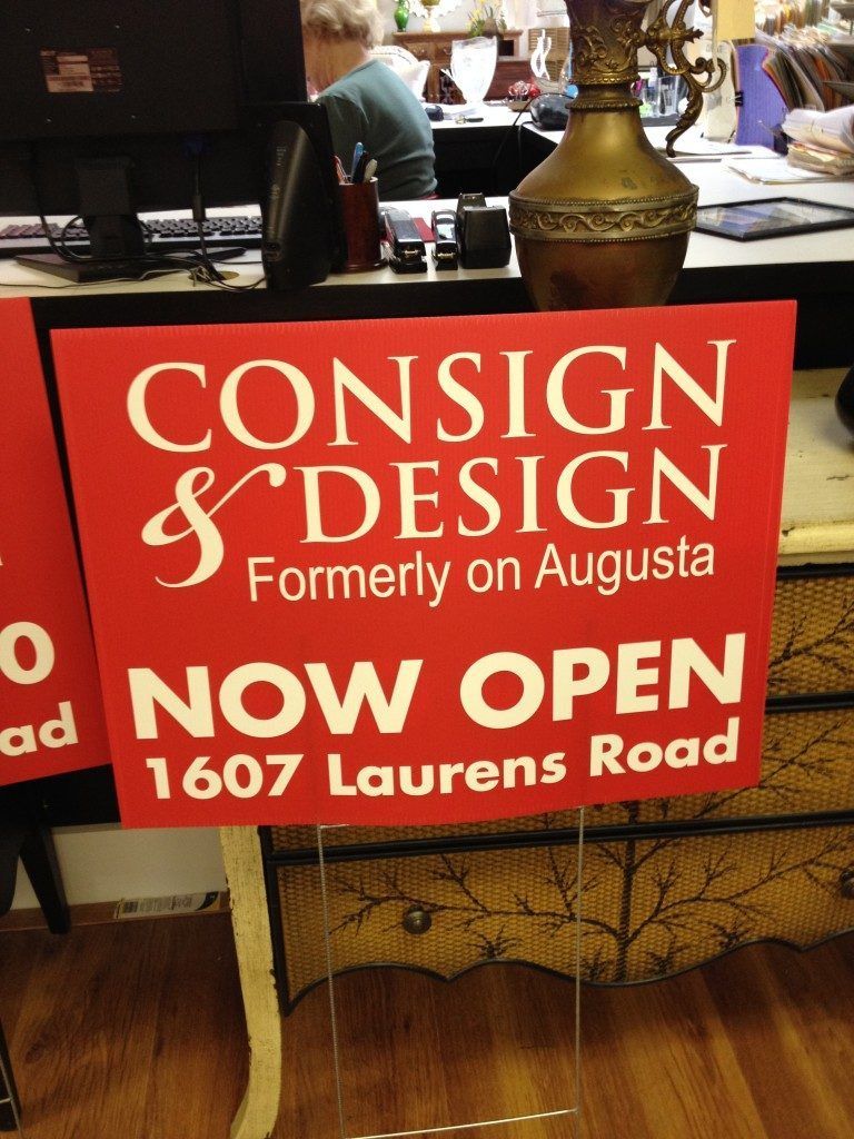 A red sign that says now open 1607 laurens road
