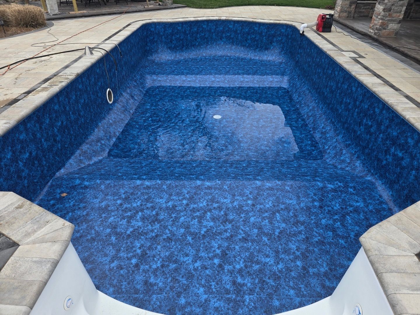 Blue tiled swimming pool, rectangular shape, concrete surround.