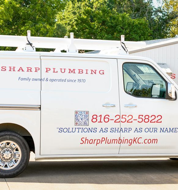 White Sharp Plumbing van with phone number, website, and logo.
