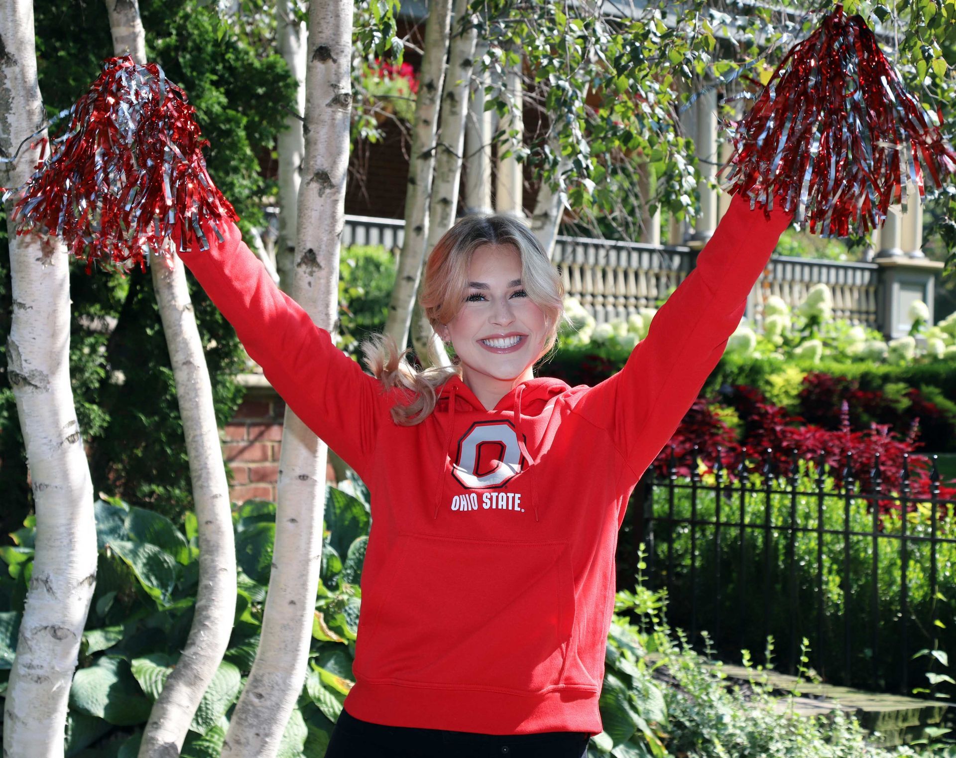 A cheerleader wearing a red sweatshirt with the letter g on it
