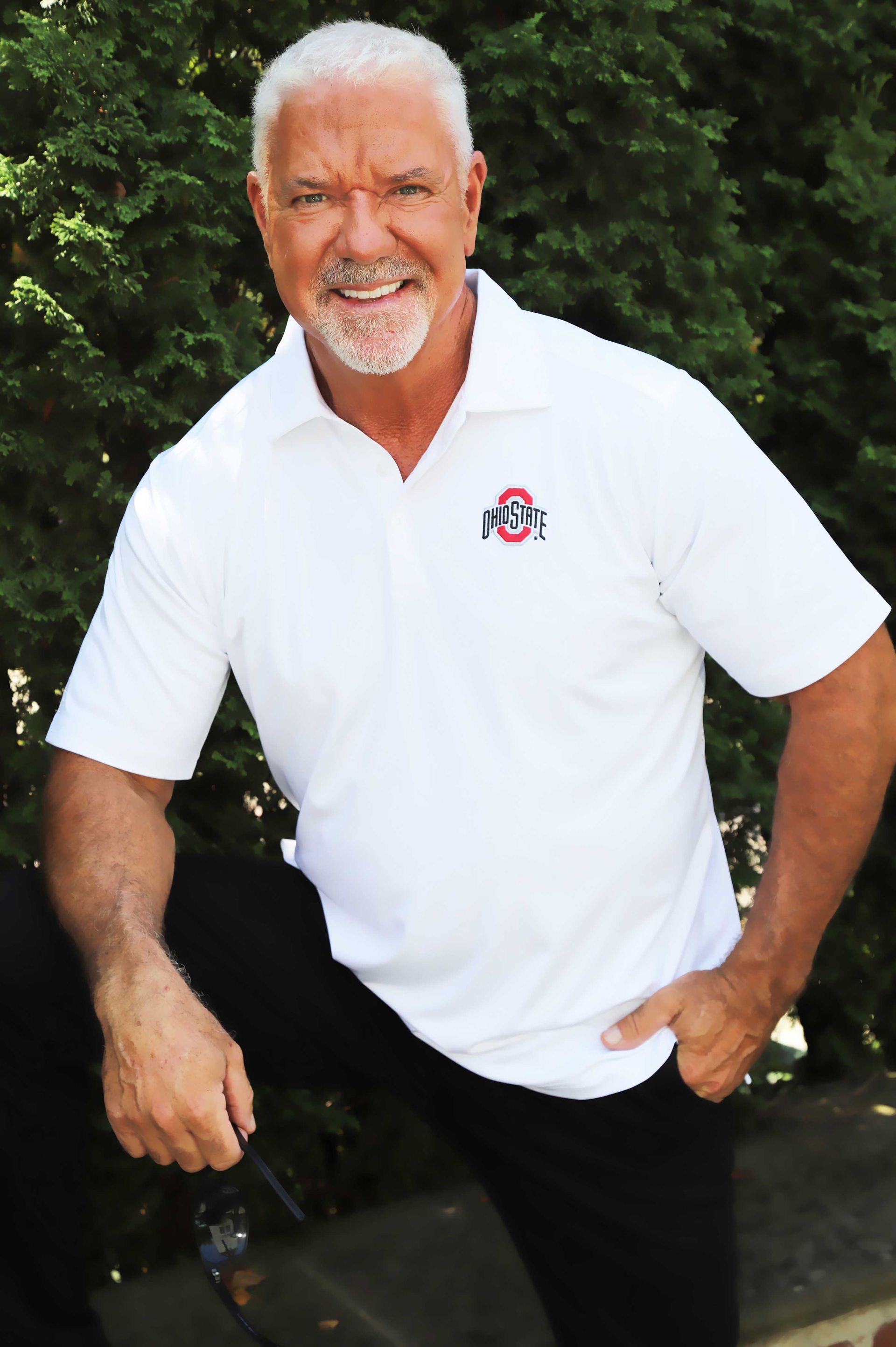 A man wearing a white polo shirt with the letter b on it