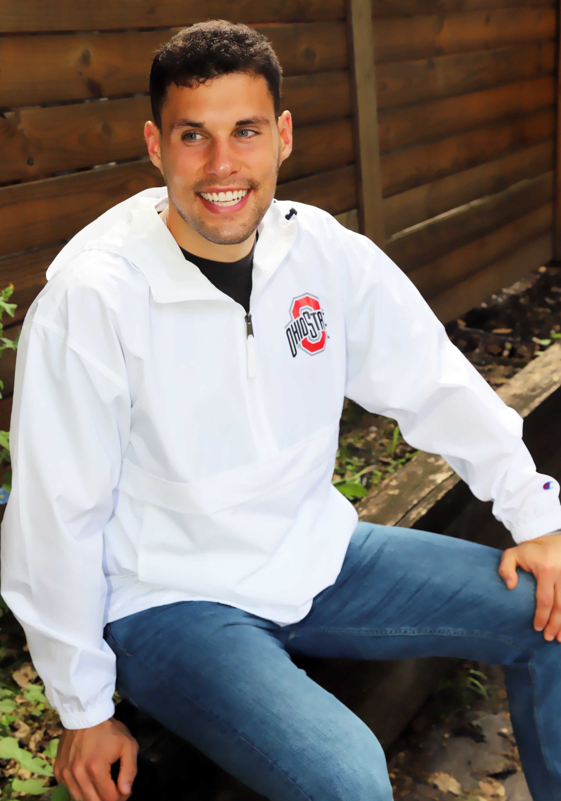 A man wearing a white jacket with the letter s on it