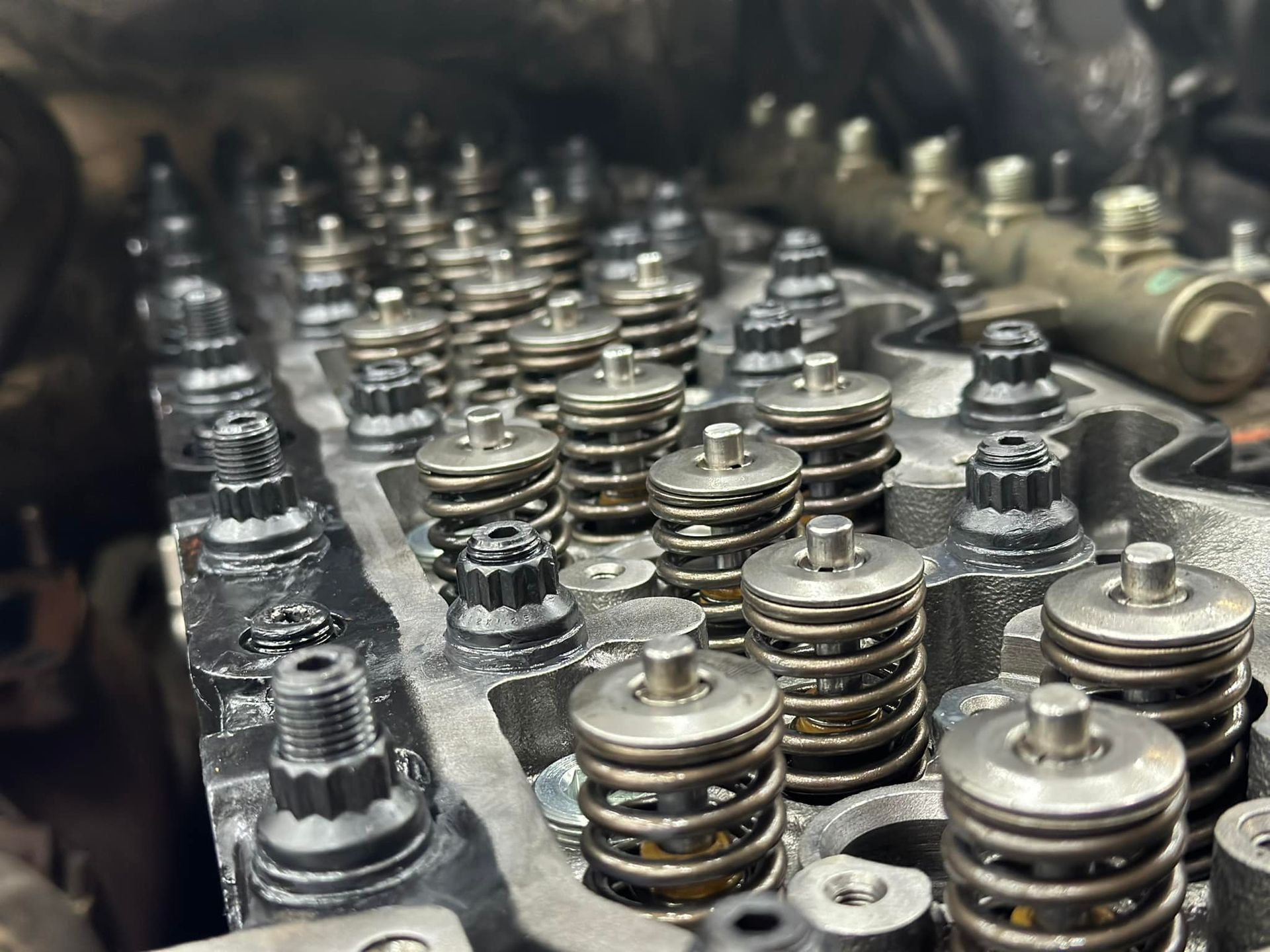A close up of a cylinder head with a lot of springs on it.