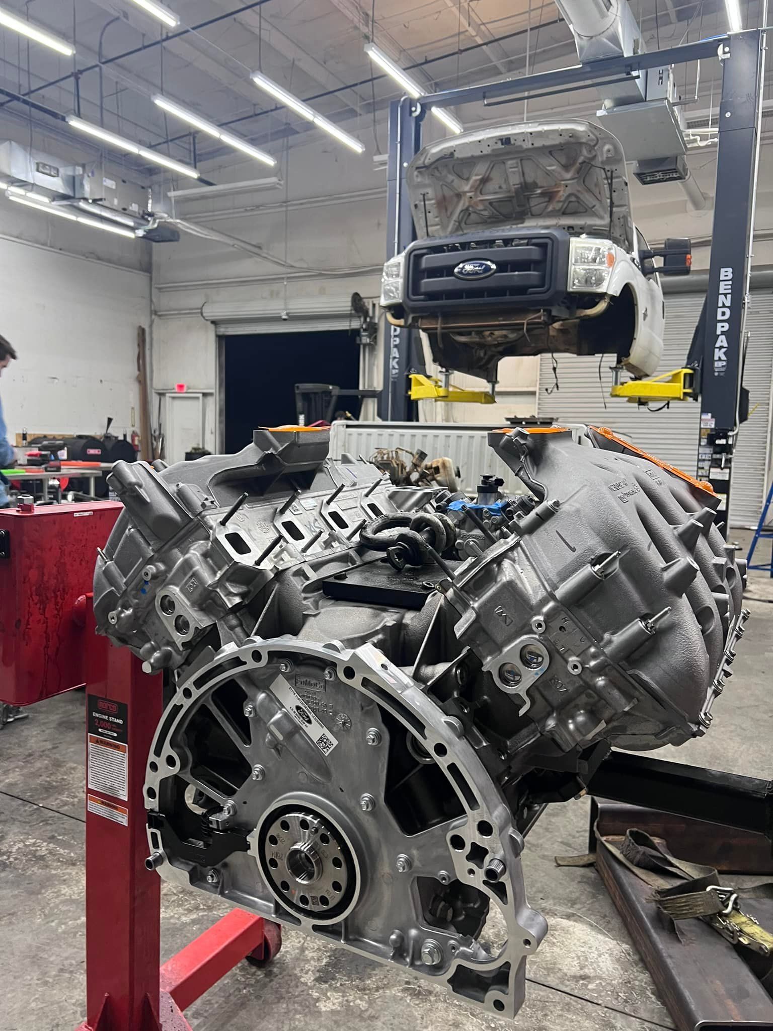 A large engine is being worked on in a garage.
