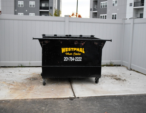 Black dumpster labeled 