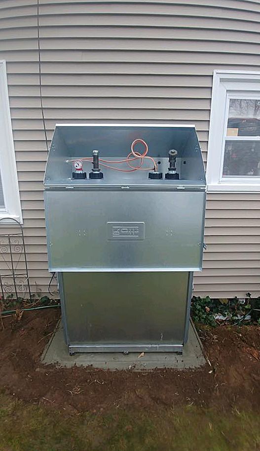 A metal box is sitting in front of a house.