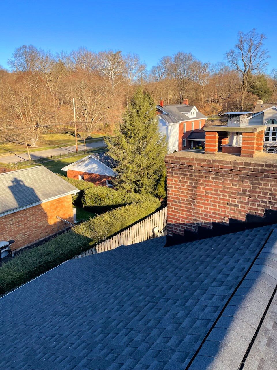 A rooftop view of a residential neighborhood with a brick chimney