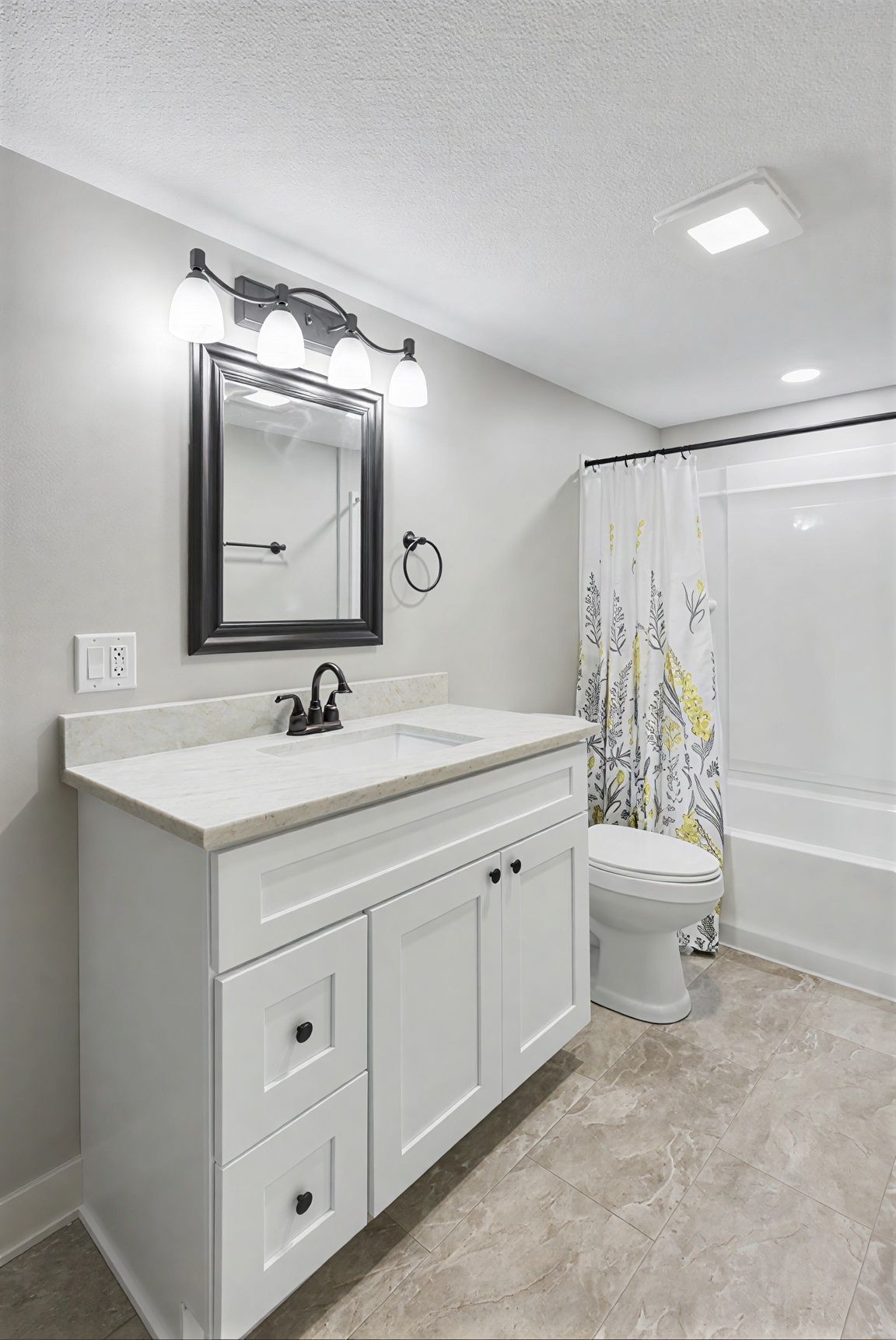 Bright modern bathroom with white vanity, mirror lights, toilet, and shower curtain