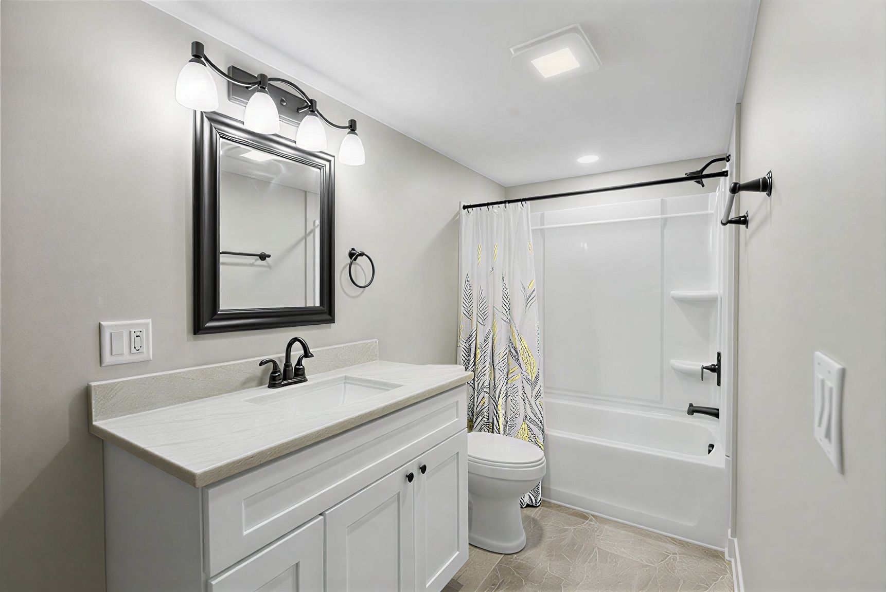 Bright white bathroom with vanity, mirror, and tub/shower combo with curtain and grab bars.