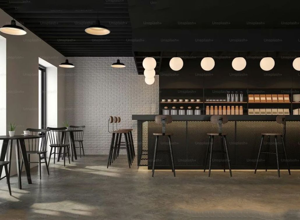 Modern bar interior with high stools, pendant lights, and a long counter against a gray tiled wall